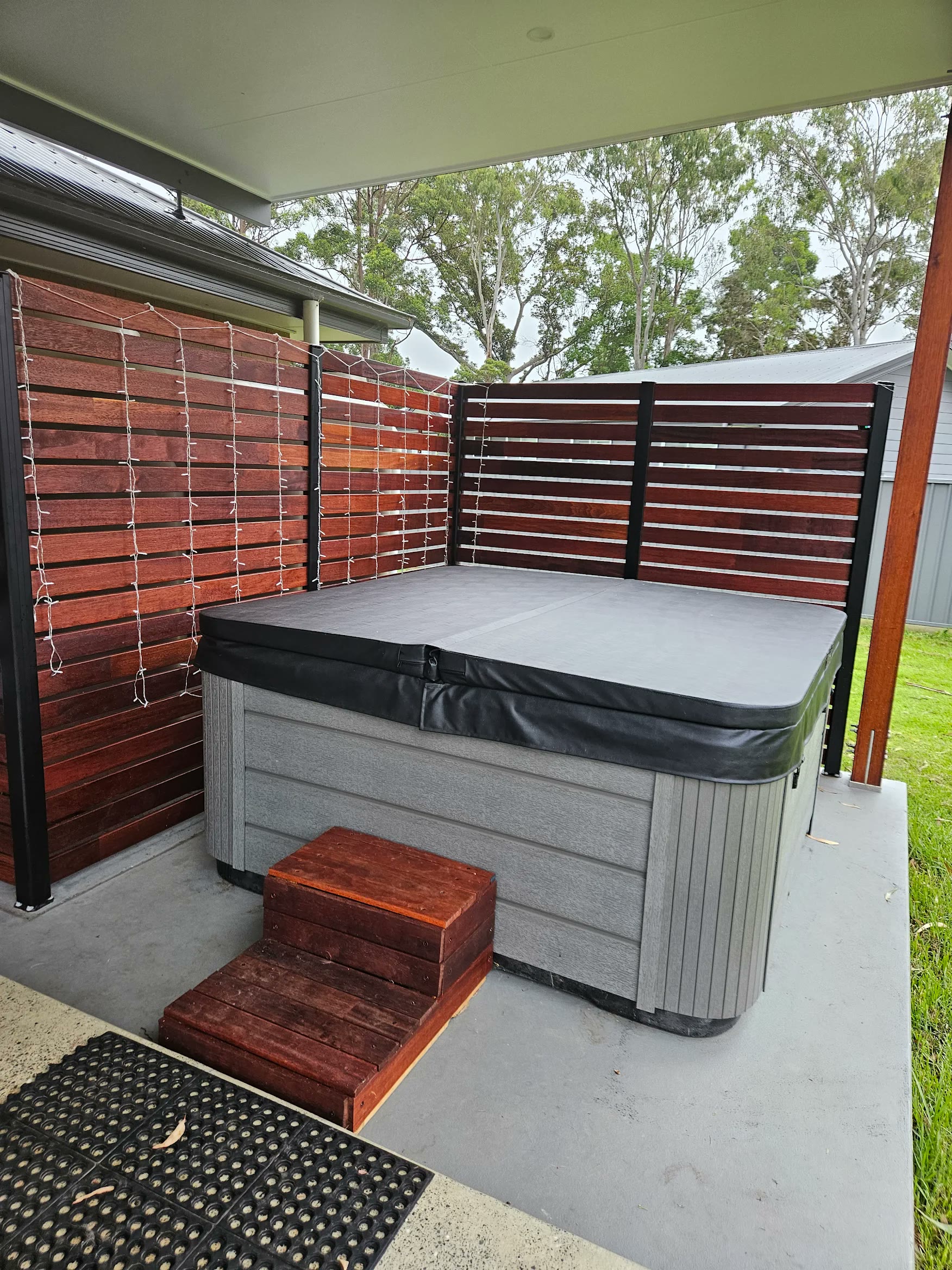 Spa against timber privacy screens with fairy lights
